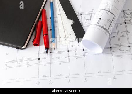 Rolls of architecture blueprints and house plans on the table and architect drawing tools. Stock Photo