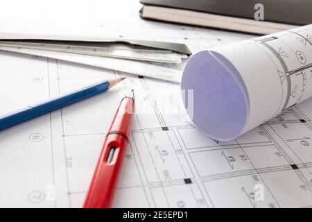 Rolls of architecture blueprints and house plans on the table and architect drawing tools. Stock Photo