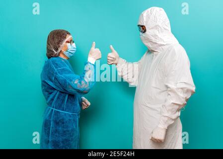 Stock photo of unrecognized person talking with healthcare worker wearing protective suit for covid19. Stock Photo