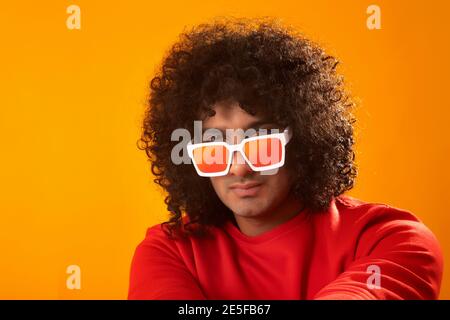 A CURLY HAIRED MAN WEARING GOGGLES POSING IN FRONT OF CAMERA Stock Photo