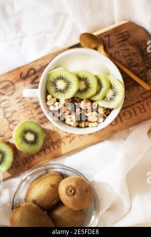 Close up shot of fresh kiwi and walnuts on a white bowl. Stock Photo