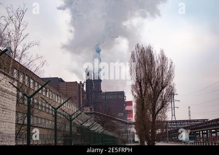 Industrial zone. Air pollution by smoke coming out of two factory chimneys.  Stock Photo