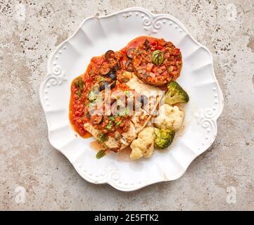 portion of cod fish with vegetables on white plate, top view Stock Photo