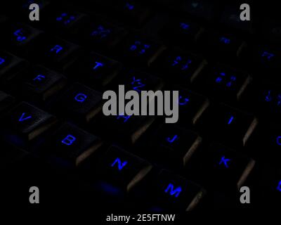 Keys on the keyboard backlit in blue in the dark Stock Photo