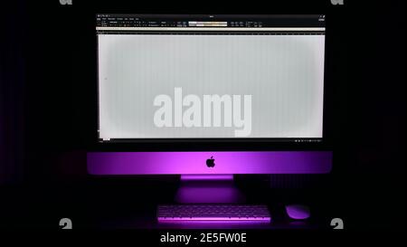 Computer screen shot of apple IMac close up on isolated black background with pink backlight. Excel spreadsheet Stock Photo