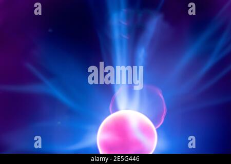 Plasma electric ball lightning lamp. Fascinating space video, close-up of electrical discharges with blue flames on a dark background. Stock Photo