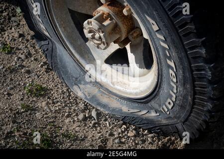 Vehicle wheel with flat tyre, Akitio, Tararua District, North Island, New Zealand Stock Photo