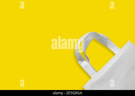 Beautiful Non Woven Grocery Shopping Bag with yellow background. Tote ECO Bags Stock Photo