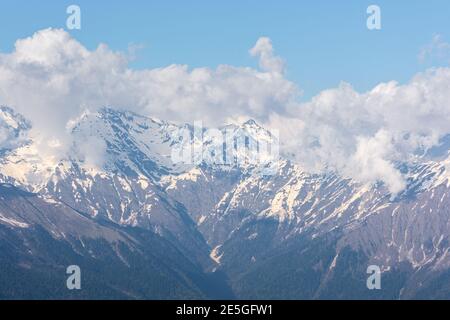 Snow-capped mountains in the clouds. Caucasian mountain range in Krasnodar Krai Sochi Krasnaya Polyana, Rosa Khutor ski resort. Beautiful atmospheric Stock Photo