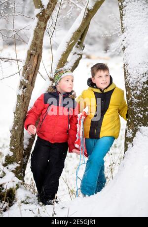 Two boys head out sledging near Wotton-under-Edge, Gloucestershire UK Stock Photo