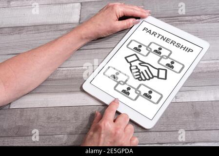 Business partnership concept shown on a tablet used by a woman Stock Photo