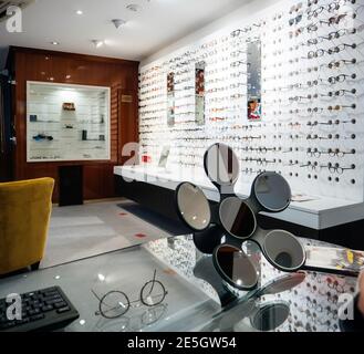 Interior of modern optician store with large selection of eyewear with floral shaped mirror on table for better view of the frame on the face Stock Photo