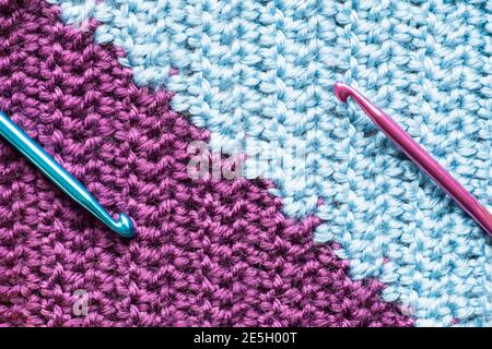 Handmade close-up simple lilac and blue crochet pattern with crochet hooks Stock Photo