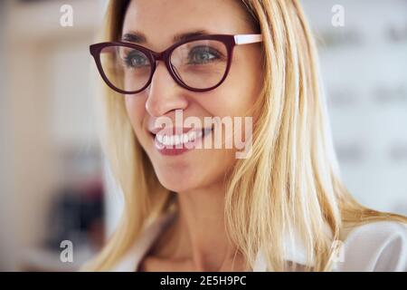 Pretty lady with beautiful smile standing in optician clinic Stock Photo