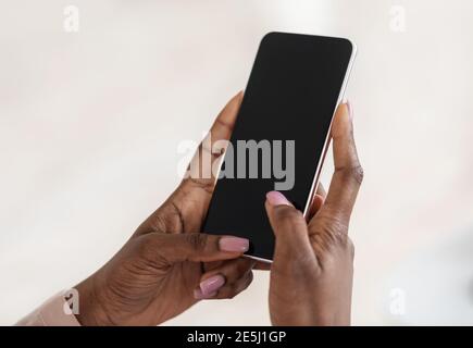 Modern Smartphone With Black Blank Screen In Hands Of Unrecognizable Black Lady, Mockup Image Stock Photo