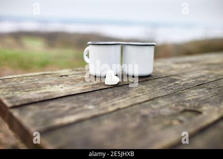Enameled Two cups of tea in nature on wooden background, love, heart of marshmallow, travel concept, Lifestyle moment at nature, Valentine day, copy s Stock Photo