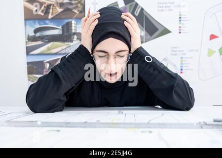 Arab female architect feeling tired Stock Photo