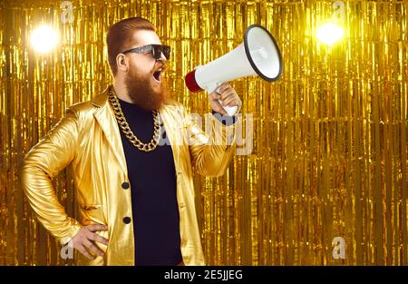 Man in golden jacket shouting in megaphone, announcing start of holiday sale or movie casting Stock Photo