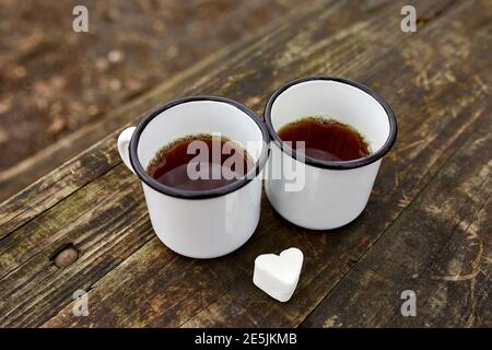 Enameled Two cups of tea in nature on wooden background, love, heart of marshmallow, travel concept, Lifestyle moment at nature, Valentine day, copy s Stock Photo