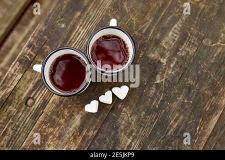 Enameled Two cups of tea in nature on wooden background, love, heart of marshmallow, travel concept, Lifestyle moment at nature, Valentine day, copy s Stock Photo