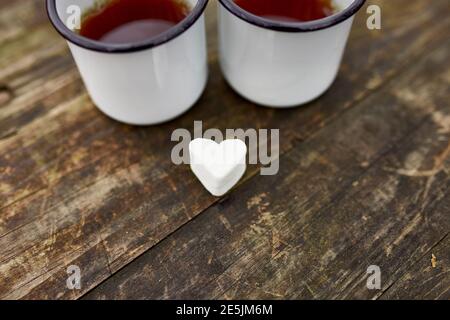 Enameled Two cups of tea in nature on wooden background, love, heart of marshmallow, travel concept, Lifestyle moment at nature, Valentine day, copy s Stock Photo