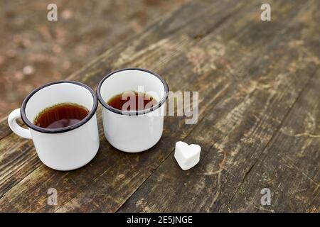 Enameled Two cups of tea in nature on wooden background, love, heart of marshmallow, travel concept, Lifestyle moment at nature, Valentine day, copy s Stock Photo