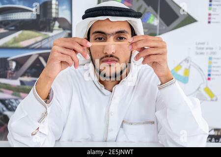 Arab male architect thinking and looking at his pencil Stock Photo