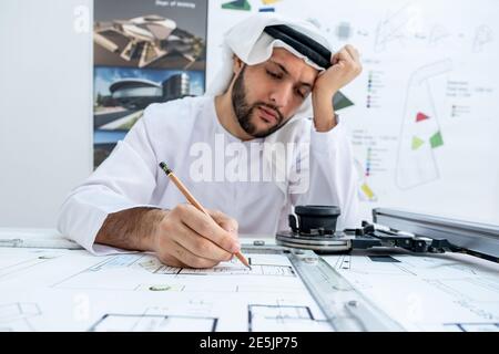 Arab male architect working while he is feeling tired Stock Photo