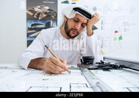 Arab male architect working while he is feeling tired Stock Photo