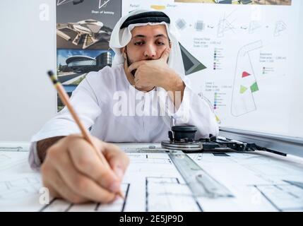 Arab male architect working while he is feeling tired Stock Photo