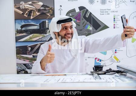 Arab male architect show hie thump up  and having an online call Stock Photo