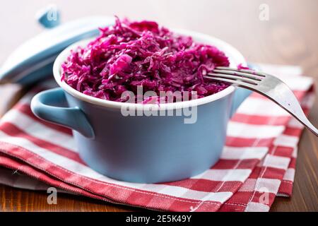 Red sauerkraut. Sour pickled cabbage in blue pot. Stock Photo