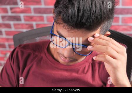 sad young man sits alone on a chair  Stock Photo
