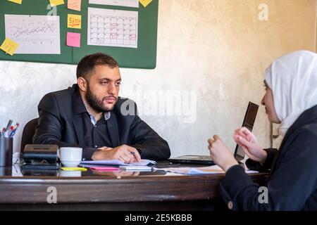 asking for forgiveness about mistake from a muslim woman to her young manager Stock Photo