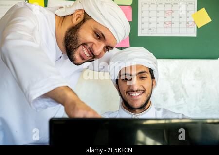 Young man take support from his colleague ,manager or supervisor to make sure from his work progress in front of his laptop in the office Stock Photo