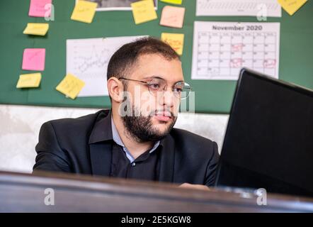 a portrait of man working in the office from home using laptop Stock Photo