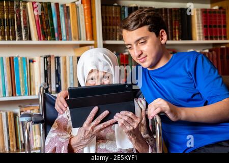 Old woman is holding her tablet Stock Photo