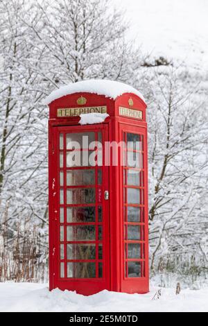 Kirkby Stephen, Cumbria, UK, 9th January 2020. A red phone box stands out among the snow in an isolated rural community, Outhgill, in Mallerstang near Stock Photo