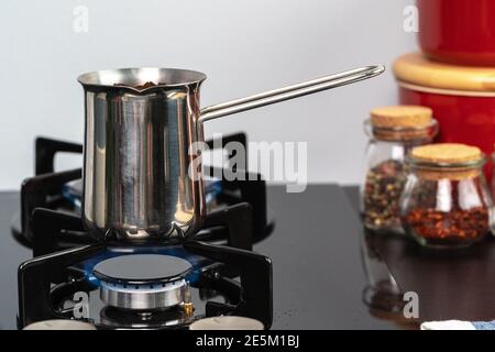 Brew coffee in a steel turk on a gas stove Stock Photo