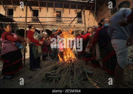 Kathmandu, NE, Nepal. 28th Jan, 2021. Hindu devotees get themselves warm before a holy bath as the month-long Madhav Narayan festival has begun at Hanumanghat, Bhaktapur of Nepal, on January 28, 2021. Credit: Aryan Dhimal/ZUMA Wire/Alamy Live News Stock Photo