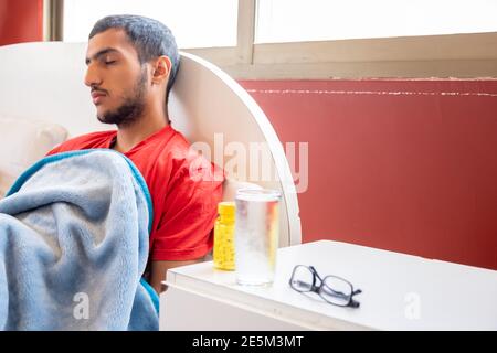 Man feeling sick, lying in the bed and trying to relax Stock Photo