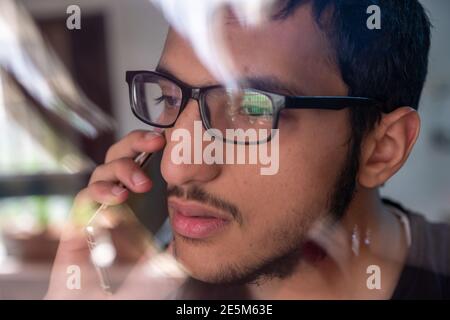 Guy talking on the phone while looking from window glass Stock Photo
