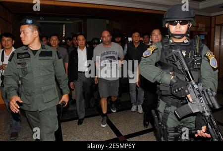 Thai policemen escort American drug suspect Joseph Hunter, 48, at Don Mueang International Airport in Bangkok September 27, 2013. Thai police transferred six foreigners suspected of drug smuggling to Bangkok on Thursday after their arrests in the seaside resort, Phuket. Hunter, along with two British, a Taiwanese, a Slovak, and a Filipino were arrested on Phuket island on Wednesday following a tip-off from the United States Drug Enforcement Administration (DEA).   REUTERS/Chaiwat Subprasom (THAILAND - Tags: CRIME LAW DRUGS SOCIETY)