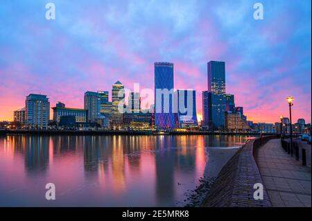 London, England, UK - January 26, 2021: Panoramic view of the modern Financial District buildings in Canary Wharf and River Thames illuminated at suns Stock Photo