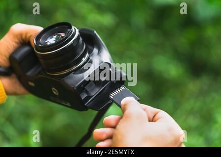 Photographer inserting the memory card into the camera Stock Photo