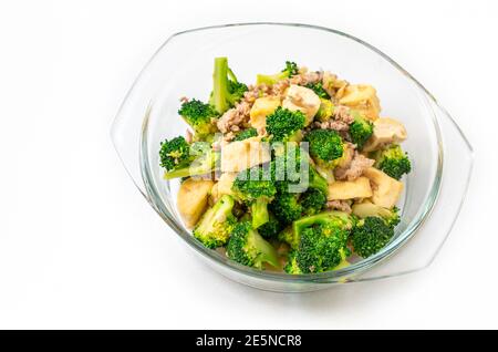 Thai homemade food, stir-fried broccoli with tofu and ground pork, food in a clear glass bowl on white background. Stock Photo