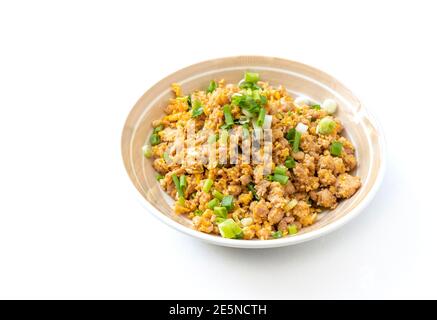 Stir-fried ground pork with egg in beautiful round dish, garnish with spring onions. Easy Asia homemade food for kid in Thailand, food image on white Stock Photo