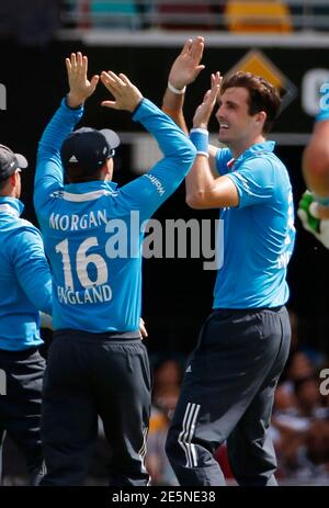 England bowler Steven Finn (R) celebrates with captain Eoin Morgan after India's batsman Ambati Rayudu was dismissed, caught by England's wicketkeeper Jos Buttler off Finn's bowling, during their One Day International (ODI) tri-series cricket match in Brisbane, January 20, 2015.  REUTERS/Edgar Su   (AUSTRALIA - Tags: SPORT CRICKET)
