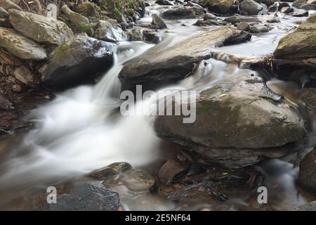 Water in a fast running stream cascading over boulders near Boone in North Carolina Stock Photo