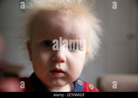 Close up of a baby boy looking directly at the camera with big blue eyes Stock Photo